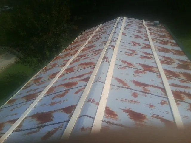 Rusted metal roof panels with new wood purlins before replacement — Storm Damage Roof Repair in New Park by Roofing Brothers
